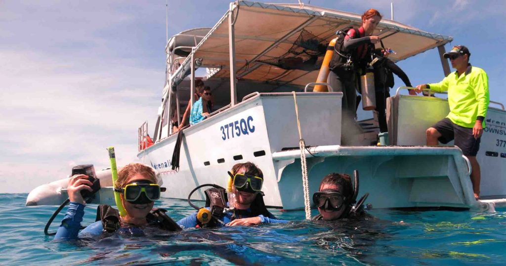advanced open water students on the surface of reef