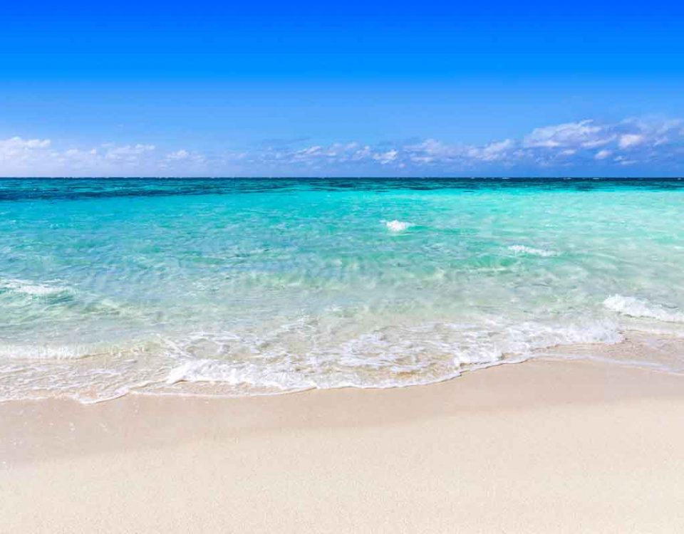 crystal clear waters as the waves lap against a sandy white beach