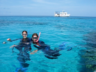 Snorkellers floating on the surface of the water with MV SeaEsta in the background